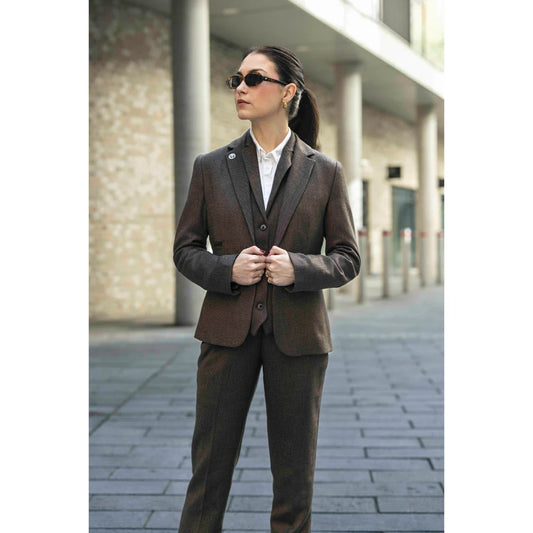 Woman wearing a brown suit standing on a street.